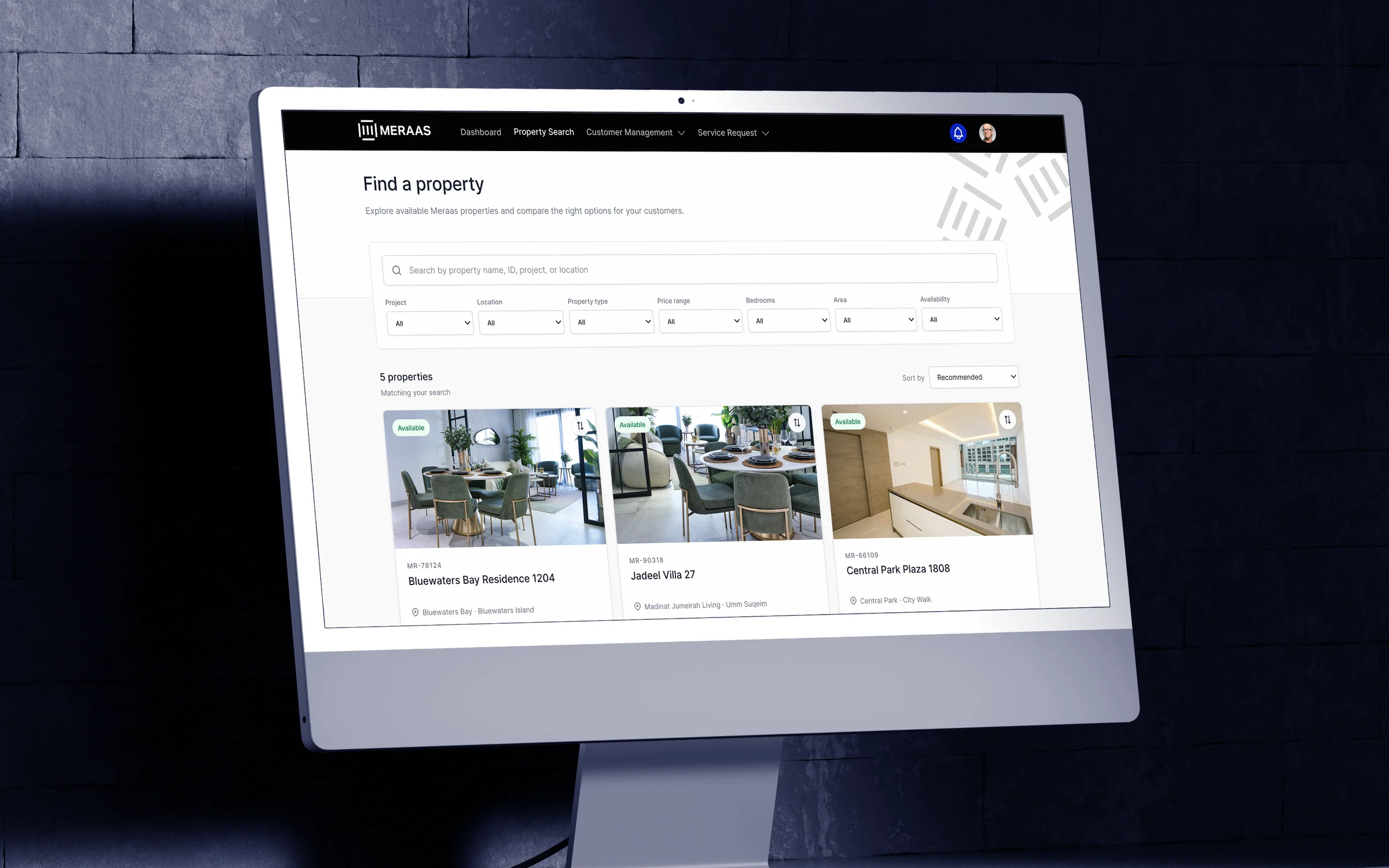 The Meraas sales portal on an angled desktop monitor: Find a property, with search filters and cards for Bluewaters Bay Residence 1204, Jadeel Villa 27 and Central Park Plaza 1808 with their prices