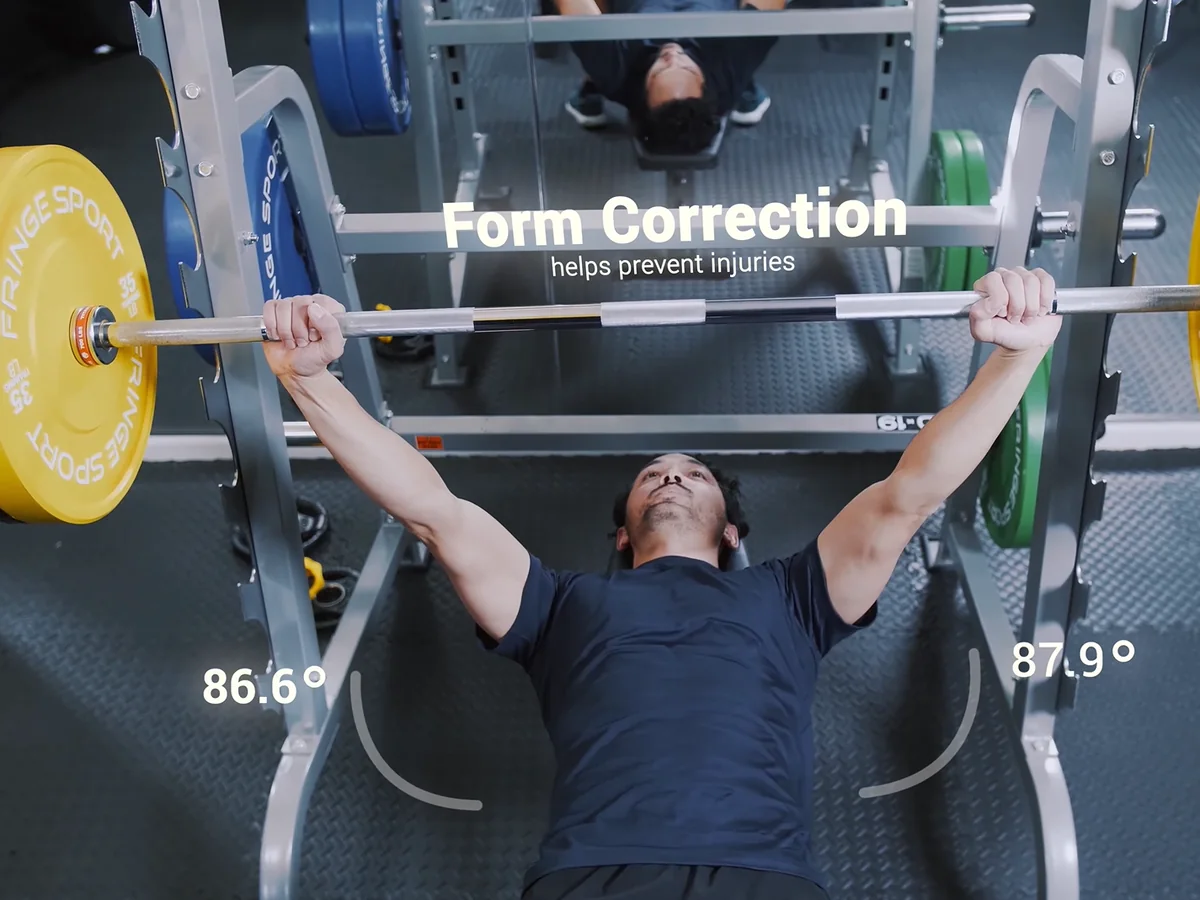 Mirror view of a bench press showing elbow angles of 86.6° and 87.9° and the note Form Correction, helps prevent injuries